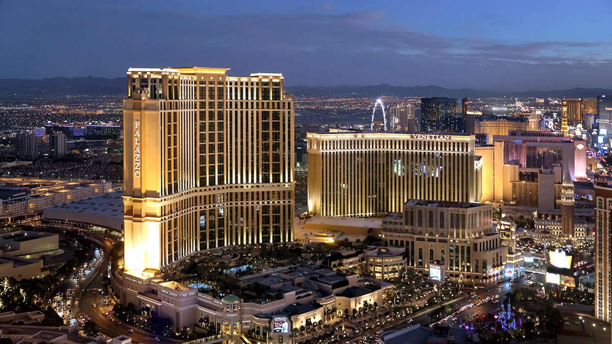 Nighttime view of Las Vegas with cars and buildings, highlighting the golden-lit Venetian Resort, a case study of Apollo’s private equity investment.