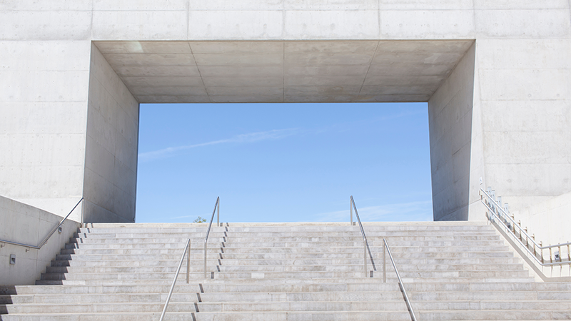 Concrete stairs rise into a clear blue sky, symbolizing Apollo’s upward momentum in 2025 through private equity, capital solutions, and equity capital markets origination.