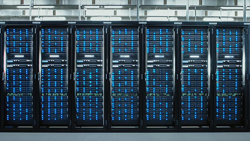 Spotlight: Financing the Digital Infrastructure Surge Row of illuminated data servers in a modern data center, representing scalable infrastructure essential to digital growth and capital markets origination.